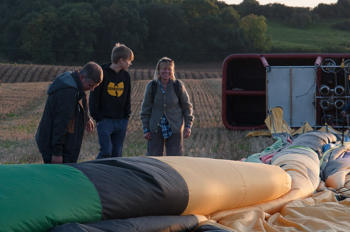 Here on a fast wind landing the basket has tipped over and the balloon has rapidly deflated as the wind on the ground drives the air out of the balloon once the opening at the top of the balloon has been operated by the pilot to stop the balloon. In lighter winds the balloon and basket may stay upright on landing. Either are perfectly safe.