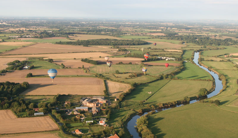 Balloons drift away from the take-off site and fly over the Yorkshire countryside.